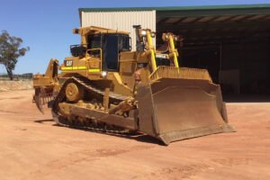 Yellow dozer with front blade used in earthmoving work
