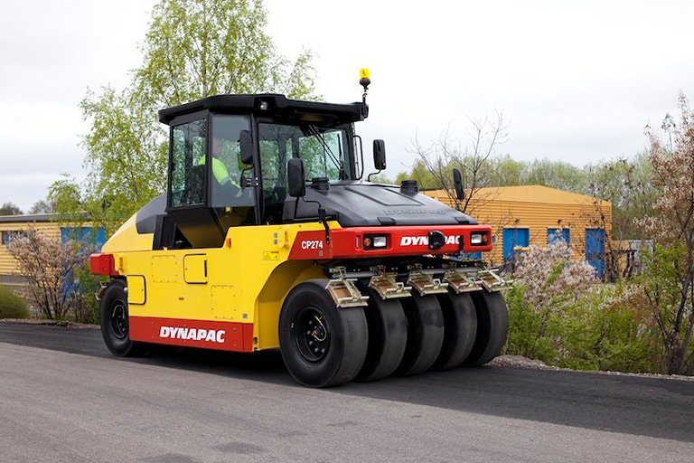 Pneumatic roller with rubber tires compacting asphalt road